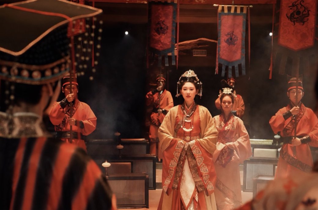A ceremonial procession beneath red dragon banners