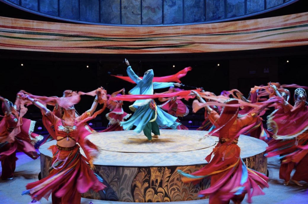 Dancers circling the round stage with silk ribbons