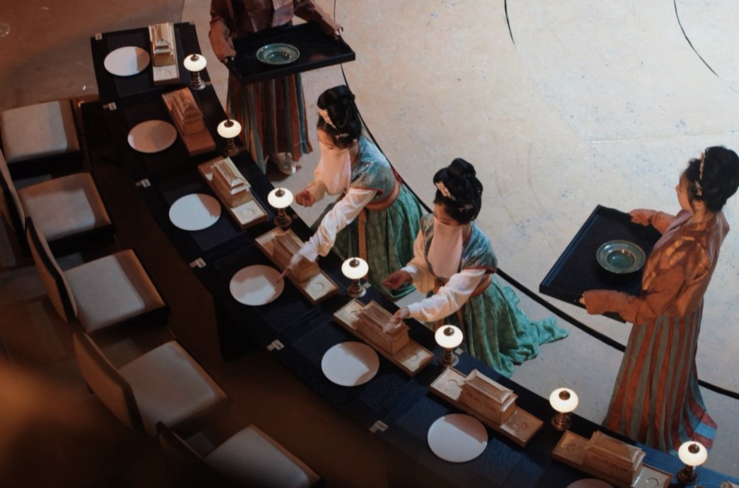Servers kneeling at the tables between courses